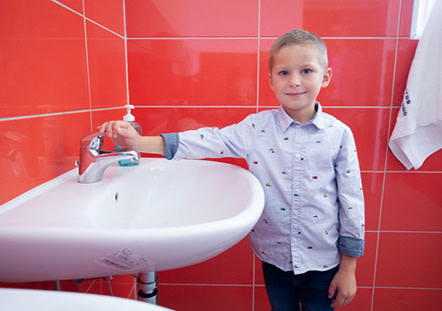 Kisfiú a mosogató mellett
