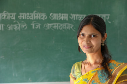 Woman in front of a green classroom board