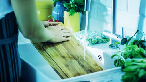 Person cleaning a chopping board