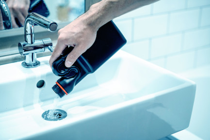 Domestos drain and pipe unblocker being poured into a drain to unblock a sink