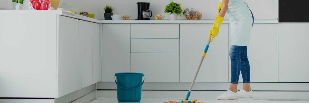 Woman mopping the floor in the Kitchen